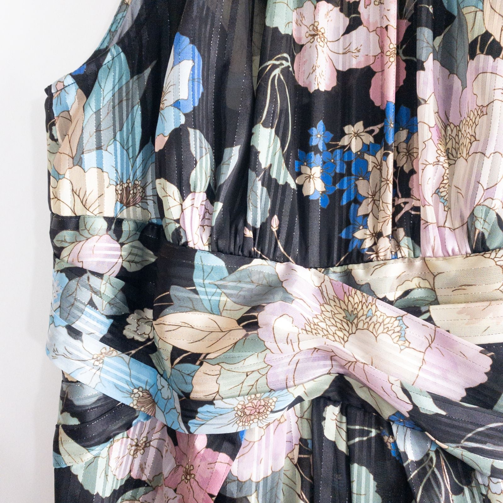 Adrianna Papell black floral maxi dress with twisted front detail hanging on clear hanger in front of white background image 4