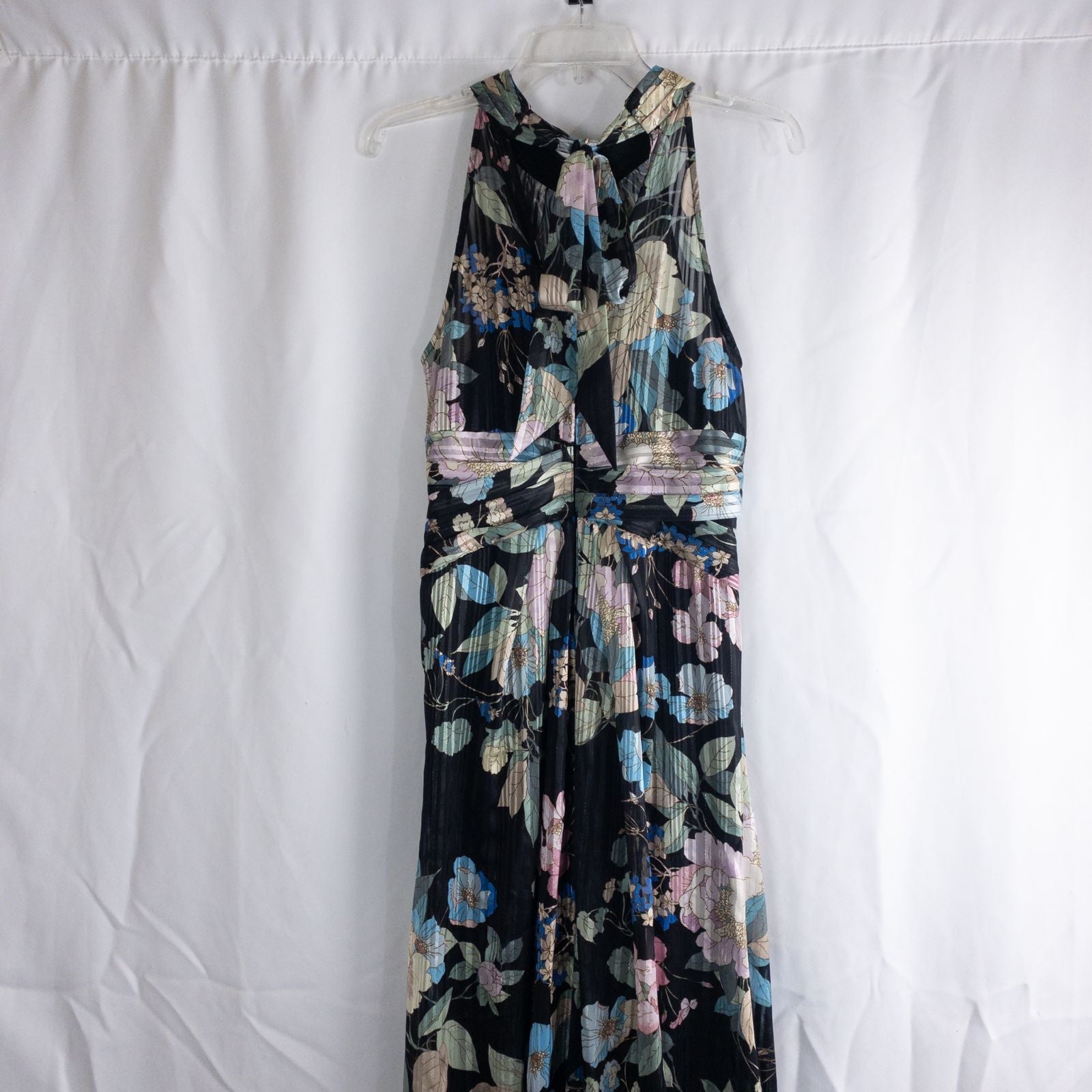 Adrianna Papell black floral maxi dress with twisted front detail hanging on clear hanger in front of white background image 6