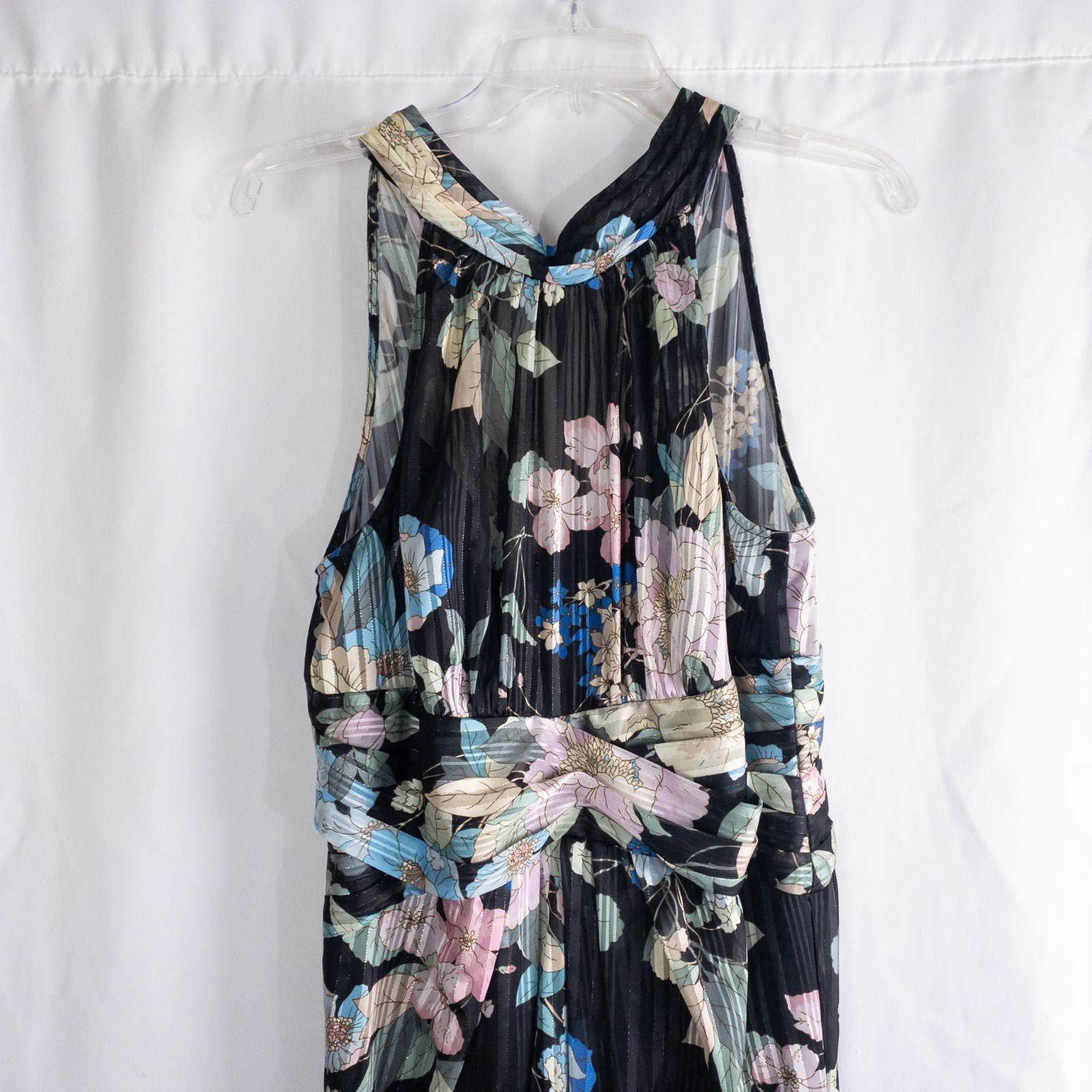 Adrianna Papell black floral maxi dress with twisted front detail hanging on clear hanger in front of white background image 2