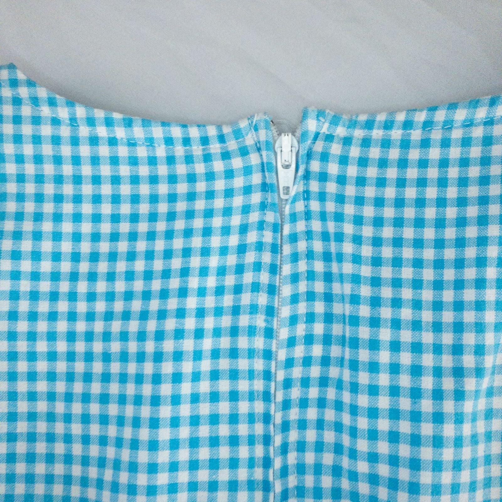 Faded Glory vintage blue and white gingham sleeveless dress with v-neck and back zipper on clear hanger against white background image 8