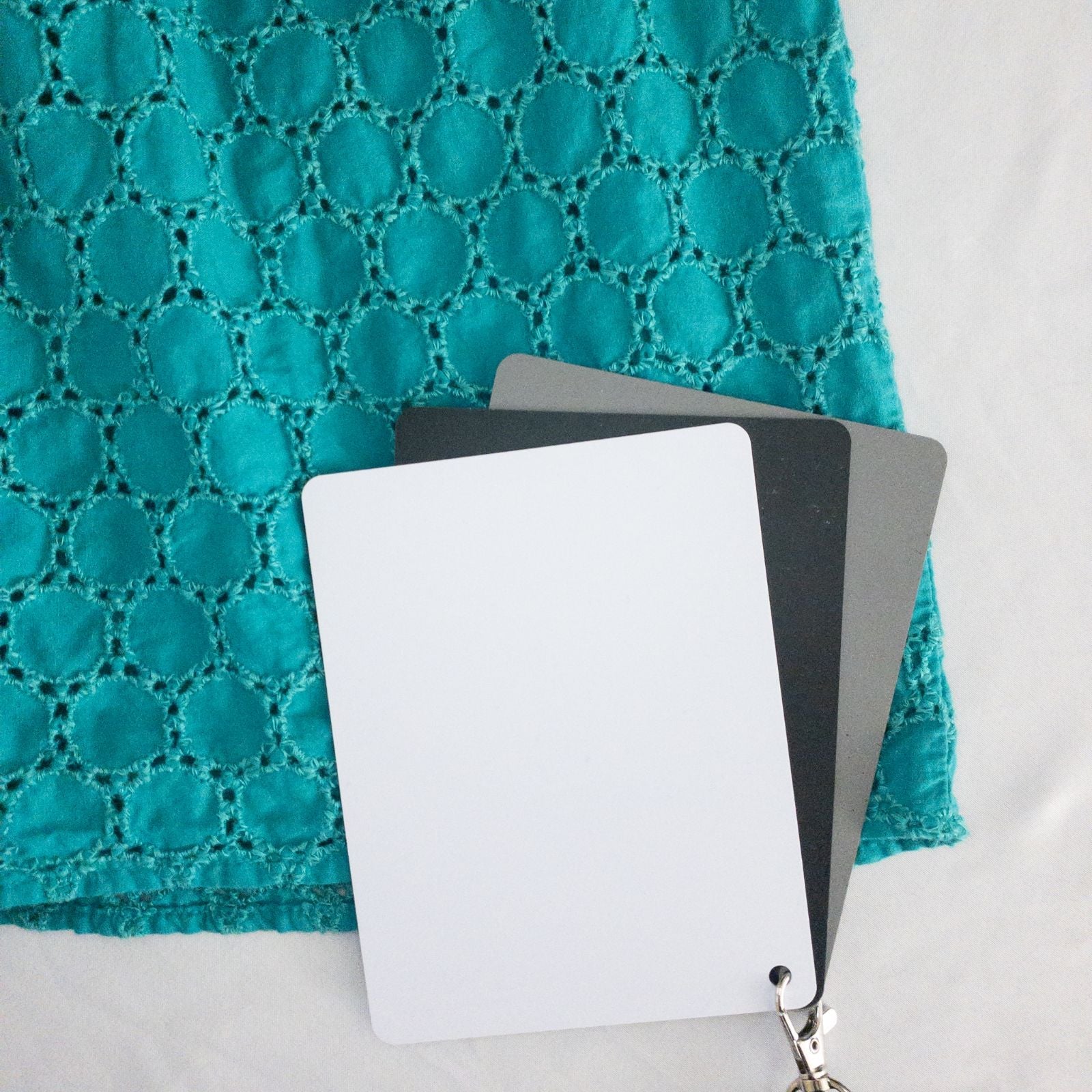 Old Navy teal green doily pattern sleeveless summer dress with gathered waist and concealed back zipper hanging on a clear hanger against a white cloth background image 8