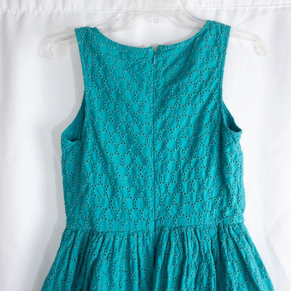 Old Navy teal green doily pattern sleeveless summer dress with gathered waist and concealed back zipper hanging on a clear hanger against a white cloth background image 7
