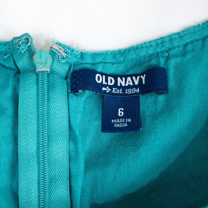Old Navy teal green doily pattern sleeveless summer dress with gathered waist and concealed back zipper hanging on a clear hanger against a white cloth background image 9