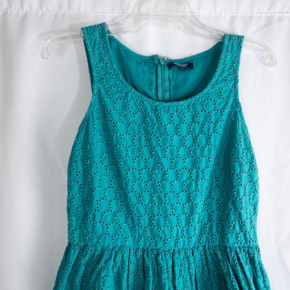 Old Navy teal green doily pattern sleeveless summer dress with gathered waist and concealed back zipper hanging on a clear hanger against a white cloth background image 2