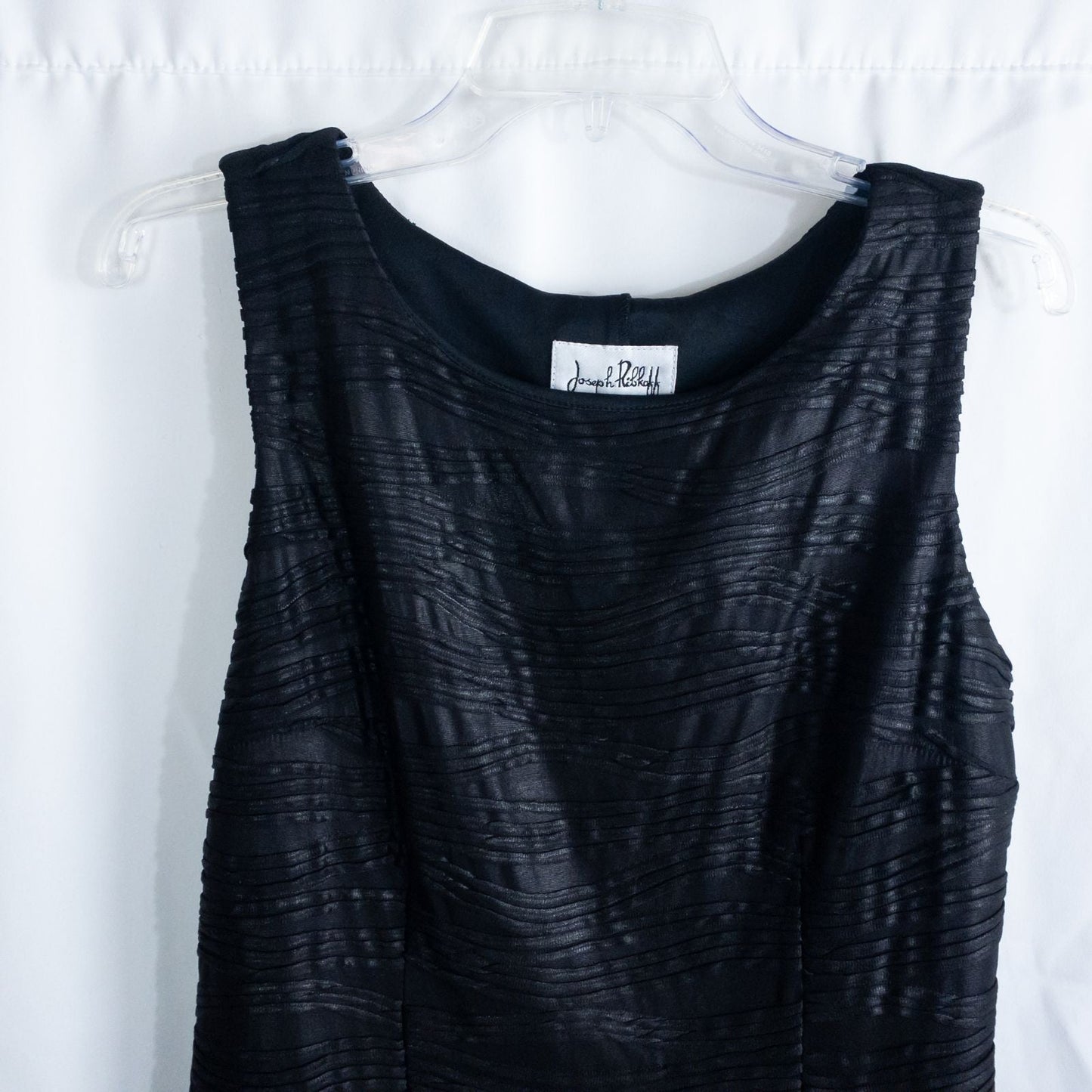 Joseph Ribkoff black pleated sleeveless minidress hanging on hanger with textured fabric image 2