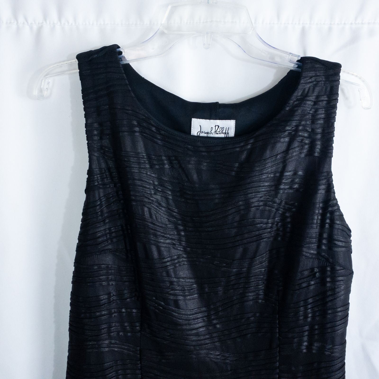Joseph Ribkoff black pleated sleeveless minidress hanging on hanger with textured fabric image 2