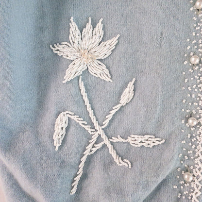 Stewarts pastel blue vintage cardigan with white bead floral embellishments and pearl buttons on a hanger image 3