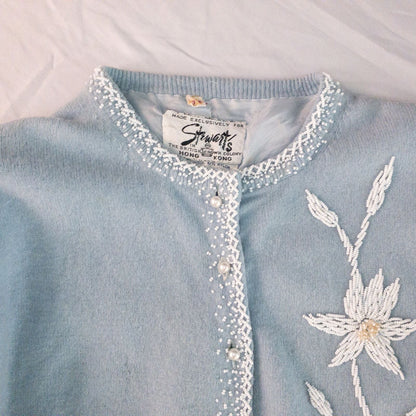 Stewarts pastel blue vintage cardigan with white bead floral embellishments and pearl buttons on a hanger image 2