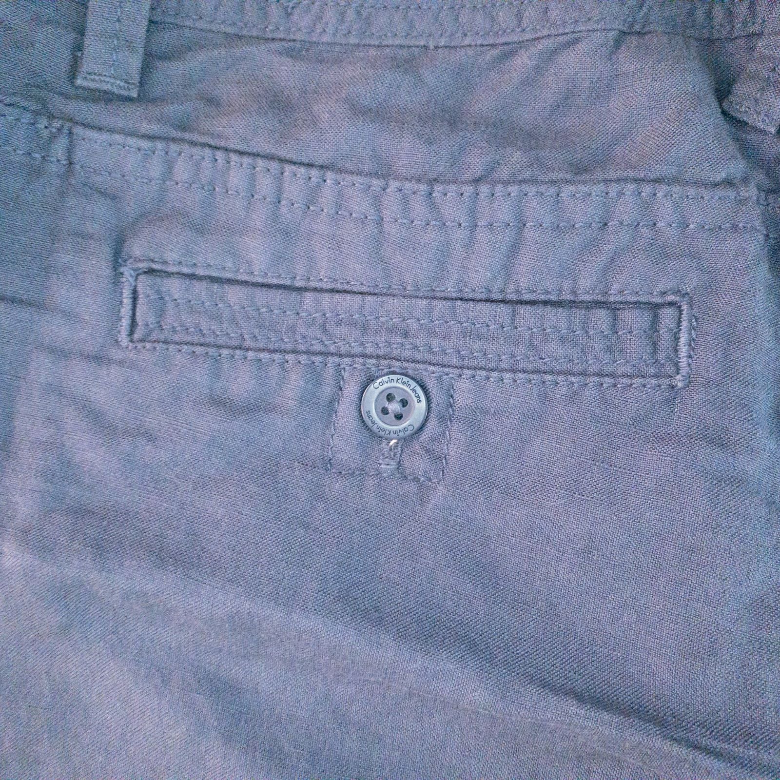 Calvin Klein blue linen shorts for women, size 4, with button closure and belt loops, front and back pockets, shown laid flat. image 7
