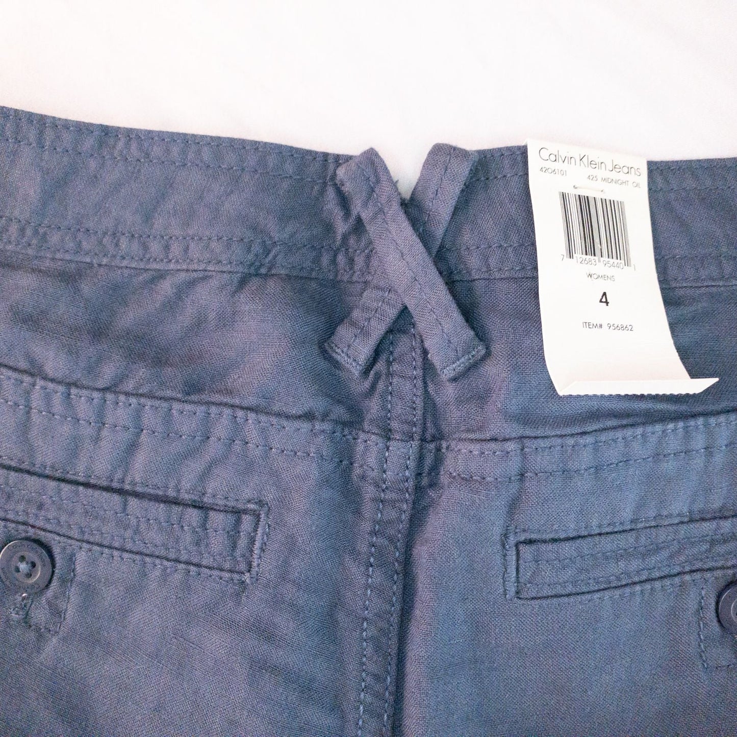 Calvin Klein blue linen shorts for women, size 4, with button closure and belt loops, front and back pockets, shown laid flat. image 8