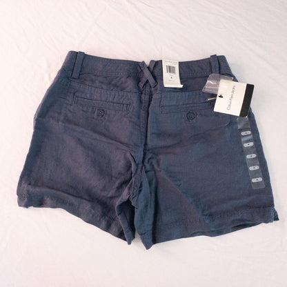 Calvin Klein blue linen shorts for women, size 4, with button closure and belt loops, front and back pockets, shown laid flat. image 6