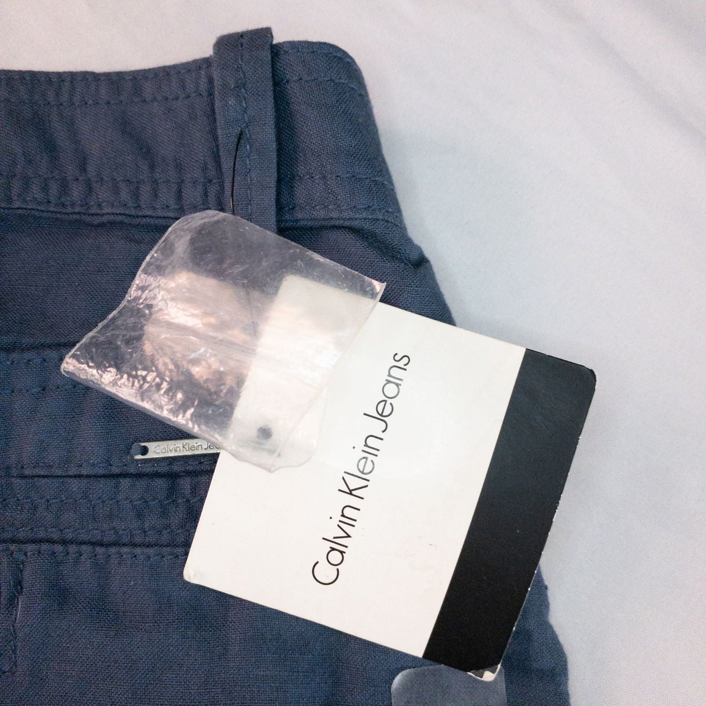 Calvin Klein blue linen shorts for women, size 4, with button closure and belt loops, front and back pockets, shown laid flat. image 11