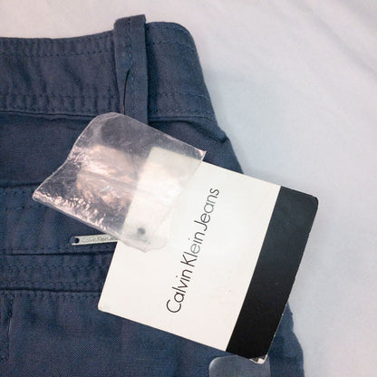 Calvin Klein blue linen shorts for women, size 4, with button closure and belt loops, front and back pockets, shown laid flat. image 11