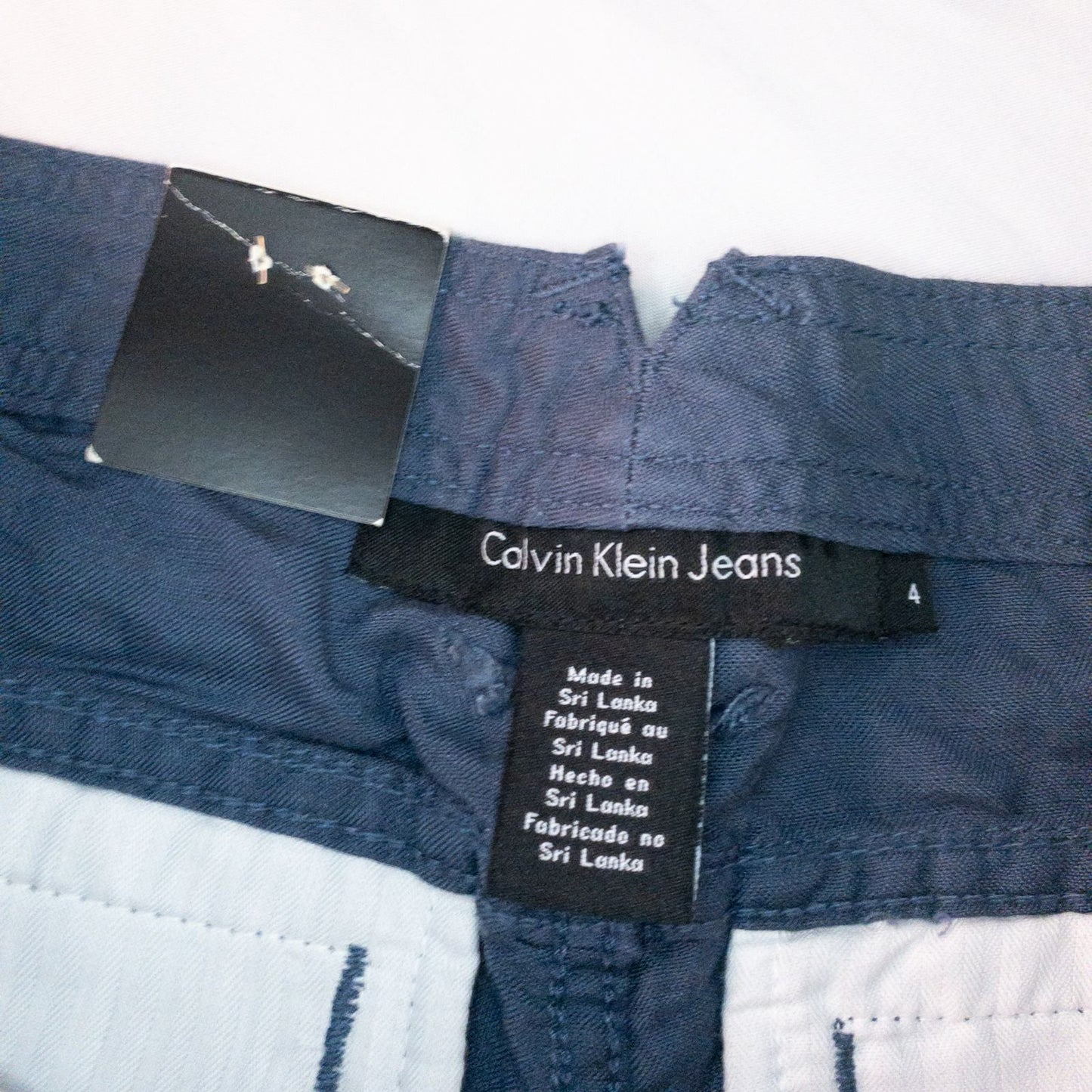 Calvin Klein blue linen shorts for women, size 4, with button closure and belt loops, front and back pockets, shown laid flat. image 9