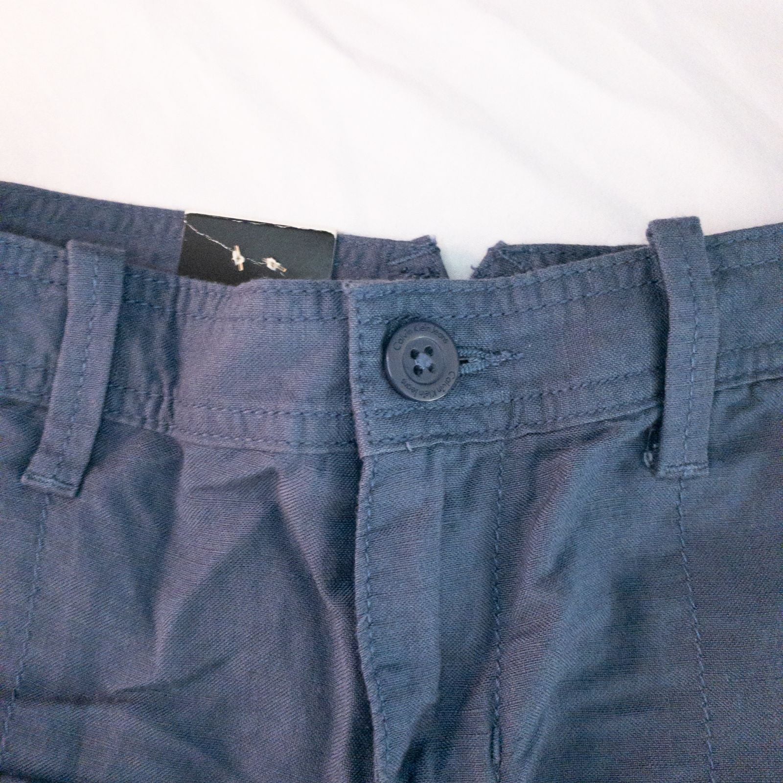 Calvin Klein blue linen shorts for women, size 4, with button closure and belt loops, front and back pockets, shown laid flat. image 2