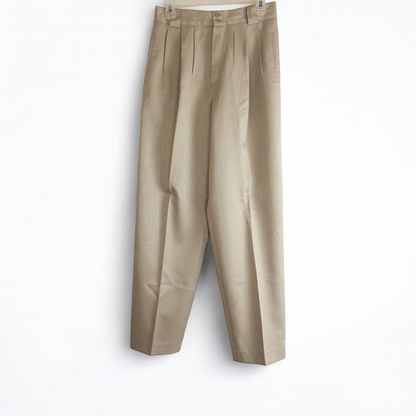 Giorgio Sant Angelo tan vintage pants with front pleats and dual button closure hanging on hanger
