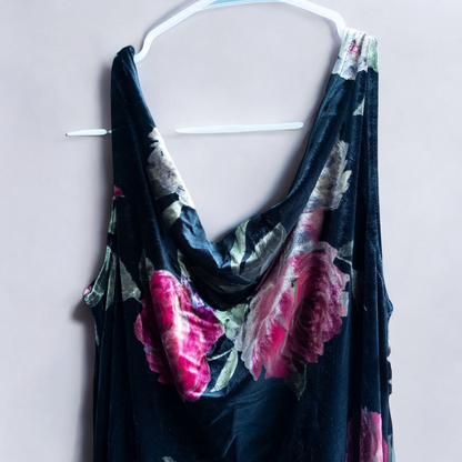 Vintage Jeffrey & Dara red rose velvet evening dress size 12 hanging in front of bookshelves showcasing black velvet fabric with red and purple rose floral pattern and cowl neckline. image 3