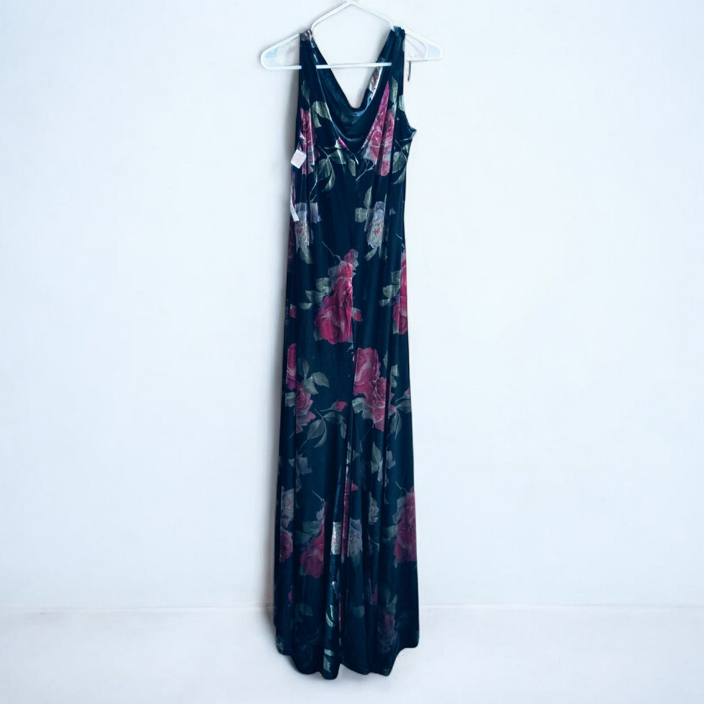 Vintage Jeffrey & Dara red rose velvet evening dress size 12 hanging in front of bookshelves showcasing black velvet fabric with red and purple rose floral pattern and cowl neckline. image 5
