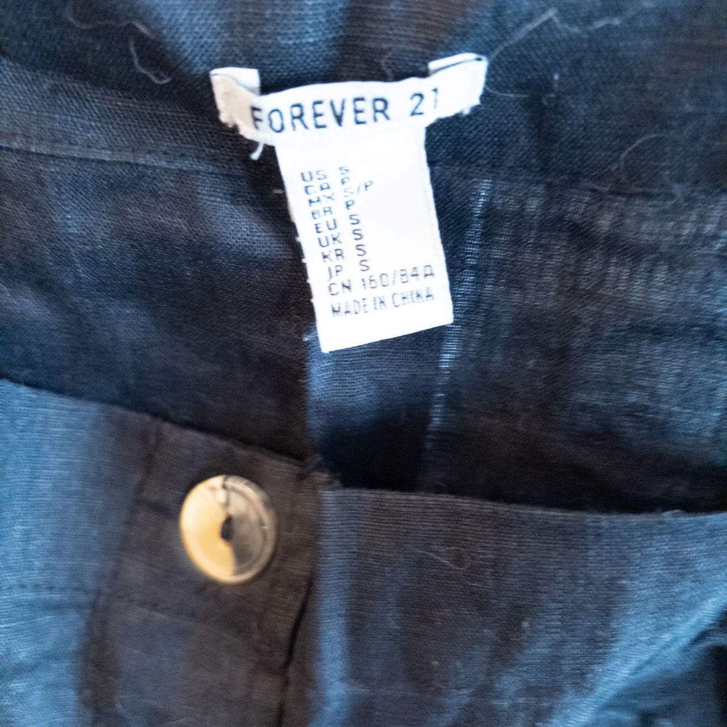 Forever 21 black linen dress with button front and adjustable straps hanging on a white hanger image 7