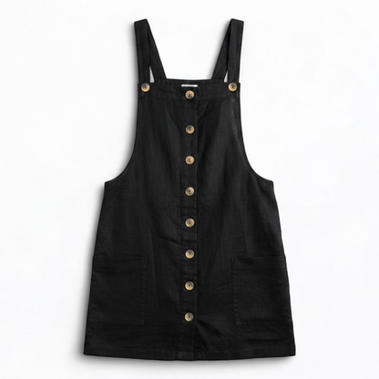Forever 21 black linen dress with button front and adjustable straps hanging on a white hanger front on white muslin photography backdrop