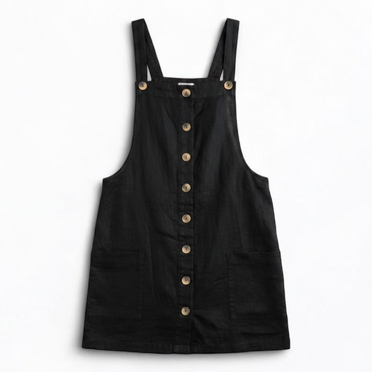 Forever 21 black linen dress with button front and adjustable straps hanging on a white hanger front on white muslin photography backdrop
