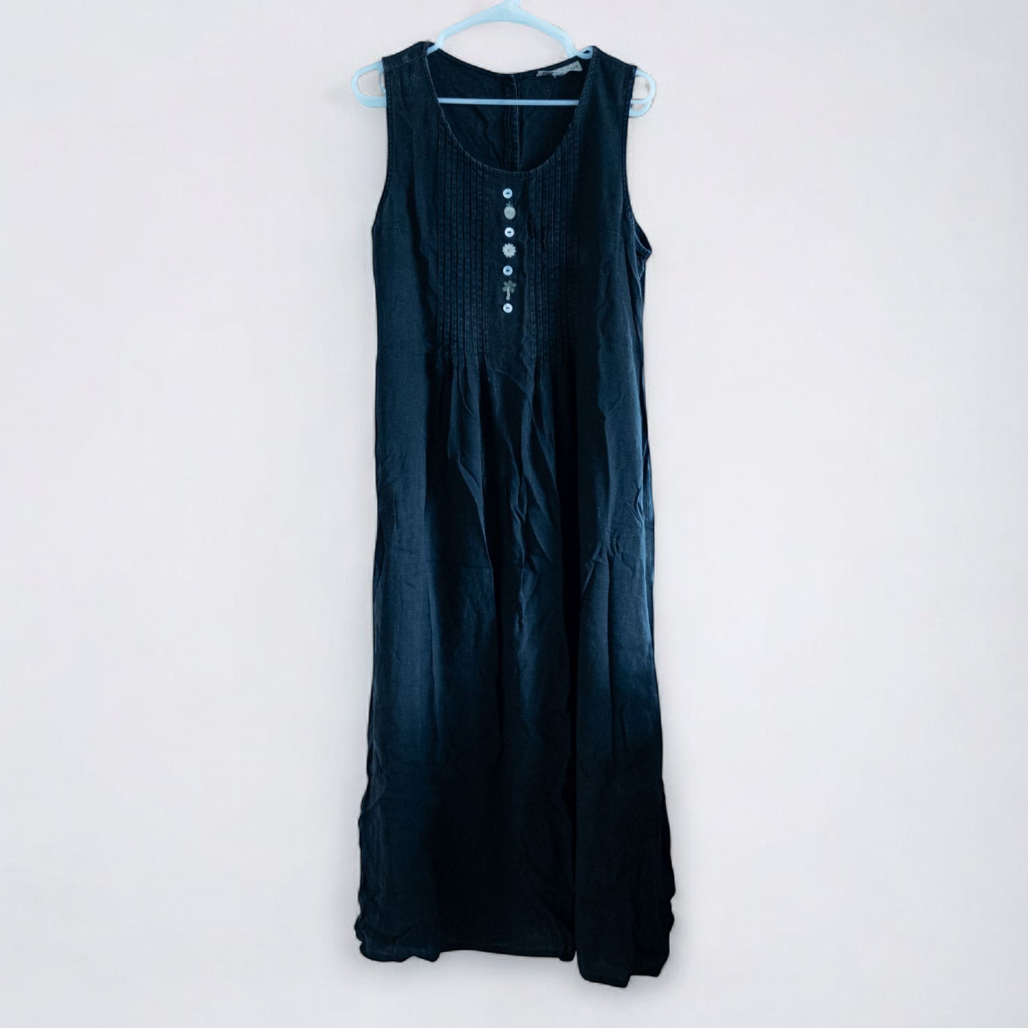 Sweet Jessie black denim long sleeveless dress with front decorative buttons and back button closure hanging on a hanger in front of a bookshelf and mirror image 2
