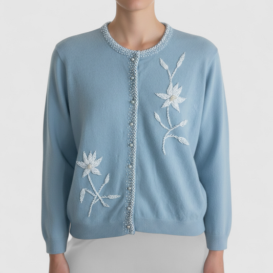 Stewarts pastel blue vintage cardigan with white bead floral embellishments and pearl buttons on a hanger on model