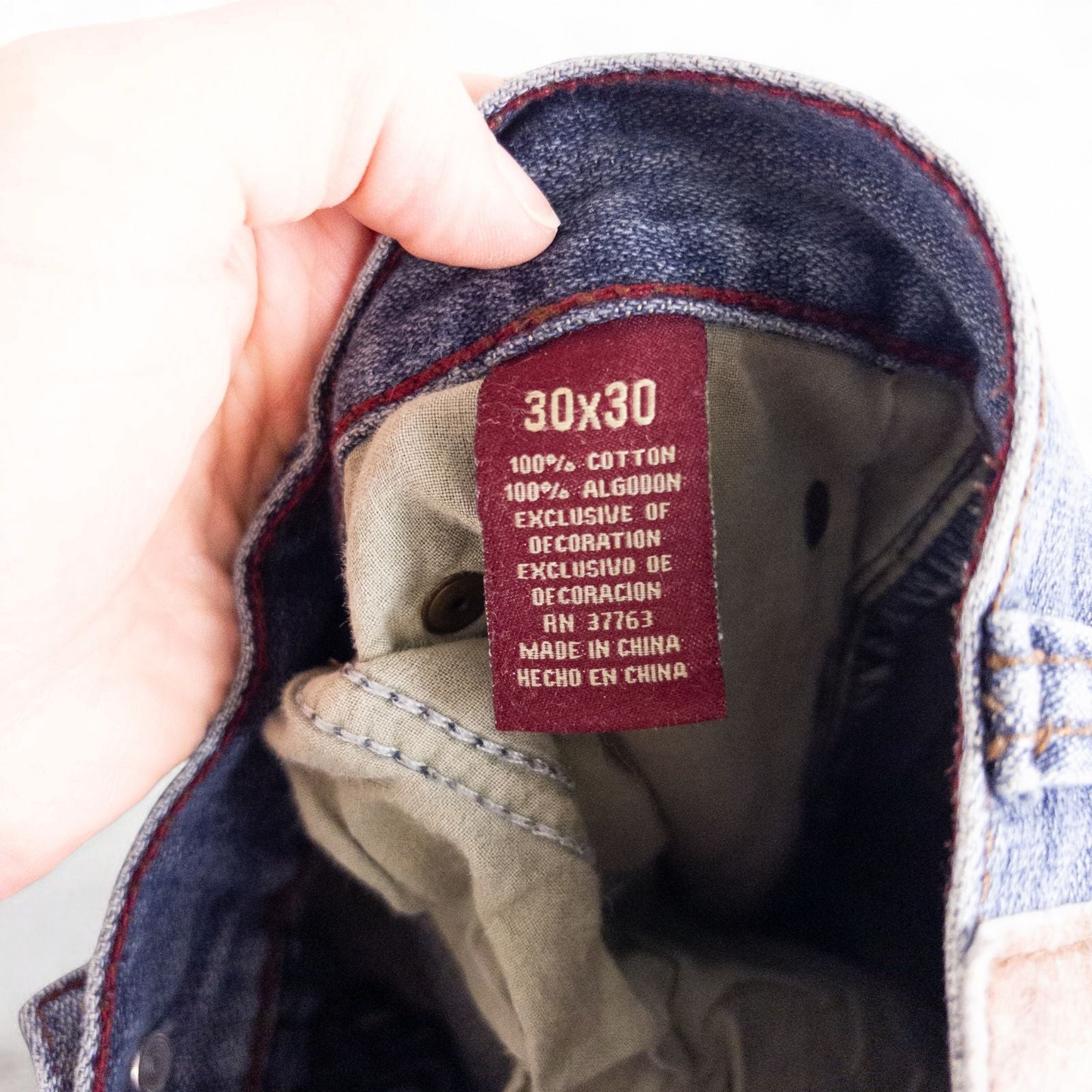 Perry Ellis women's blue denim jeans with five pockets hanging on a hanger front and back views image 11