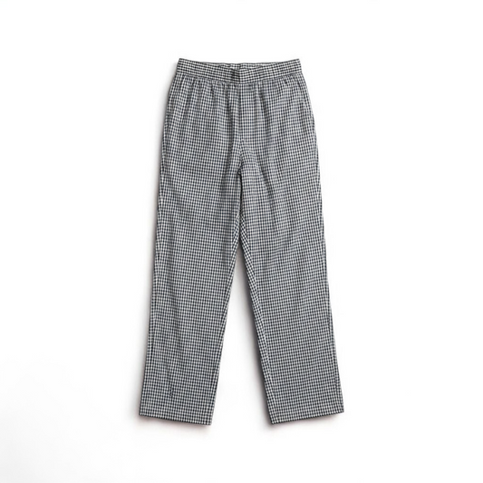 Mercer Culinary black and white houndstooth high rise pants in womens small size hanging on plastic hanger against white background showing front, side pockets, and back Mercer Culinary logo front on white muslin photography backdrop