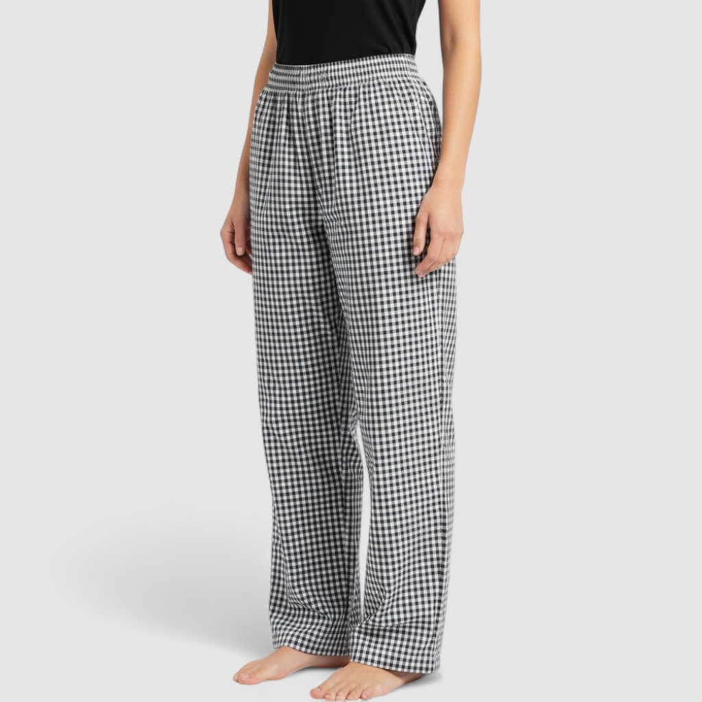 Mercer Culinary black and white houndstooth high rise pants in womens small size hanging on plastic hanger against white background showing front, side pockets, and back Mercer Culinary logo on model
