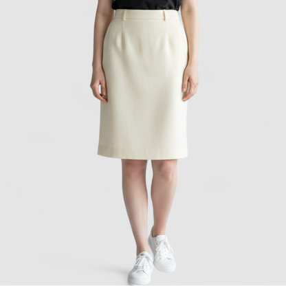 Vintage ivory pique pencil skirt with side zipper and button tab detail hanging on a hanger on model
