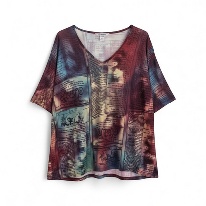 Nygard multicolor horoscope boho top with v-neck and short sleeves hanging on plastic hanger front on white muslin photography backdrop