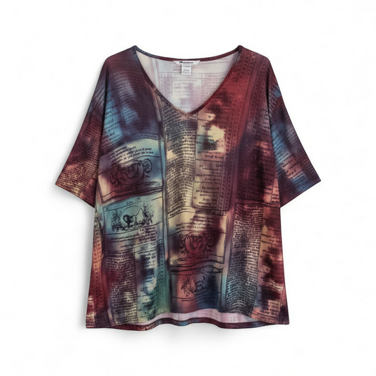 Nygard multicolor horoscope boho top with v-neck and short sleeves hanging on plastic hanger front on white muslin photography backdrop