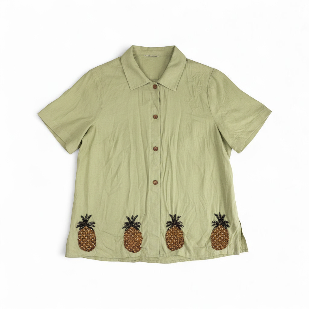Vintage beaded pineapple linen short sleeve shirt in muted green with wooden buttons and detailed beadwork on pineapples front on white muslin photography backdrop