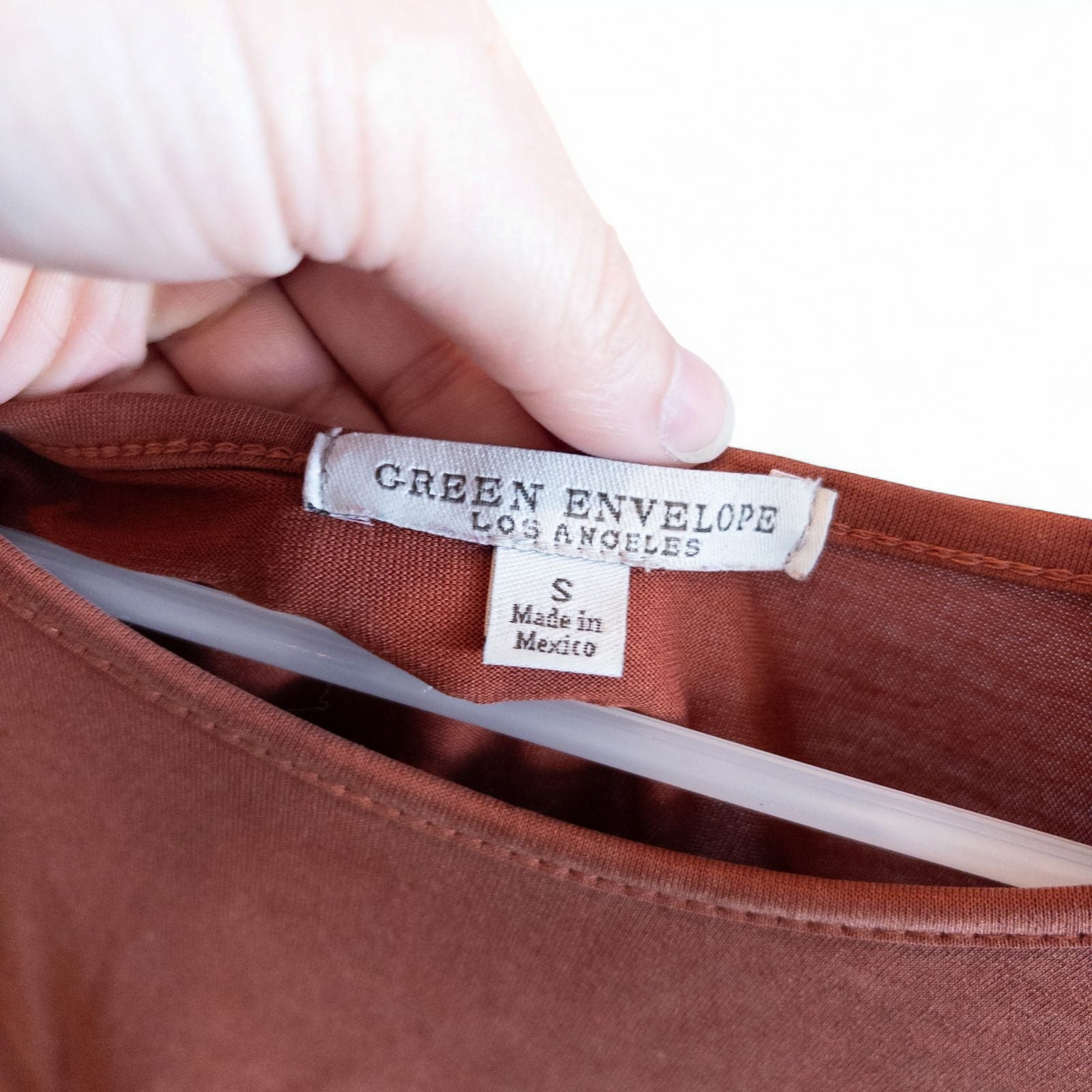 Green Envelope rust color womens small button back shirt hanging on white background image 3