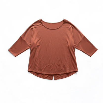 Green Envelope rust color womens small button back shirt hanging on white background front on white muslin photography backdrop