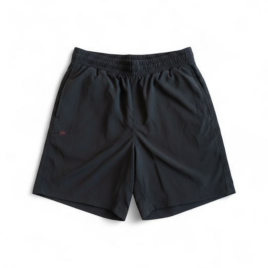 Rhone black athletic shorts for men with elastic waistband and zippered pockets hanging on hanger front on white muslin photography backdrop