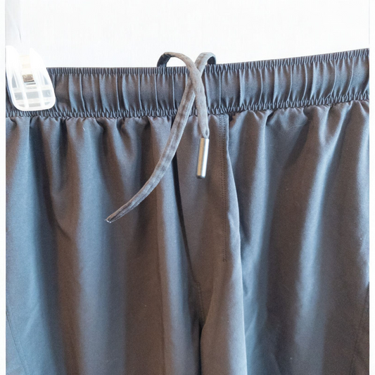 Black lululemon men's lightweight athletic shorts with elastic waistband and drawstring tie hanging on clips image 2