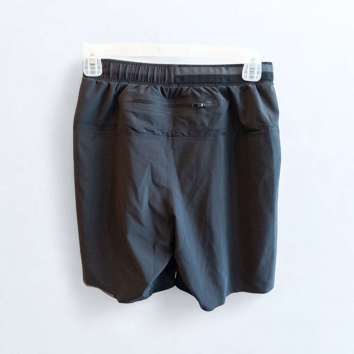 Black lululemon men's lightweight athletic shorts with elastic waistband and drawstring tie hanging on clips image 4