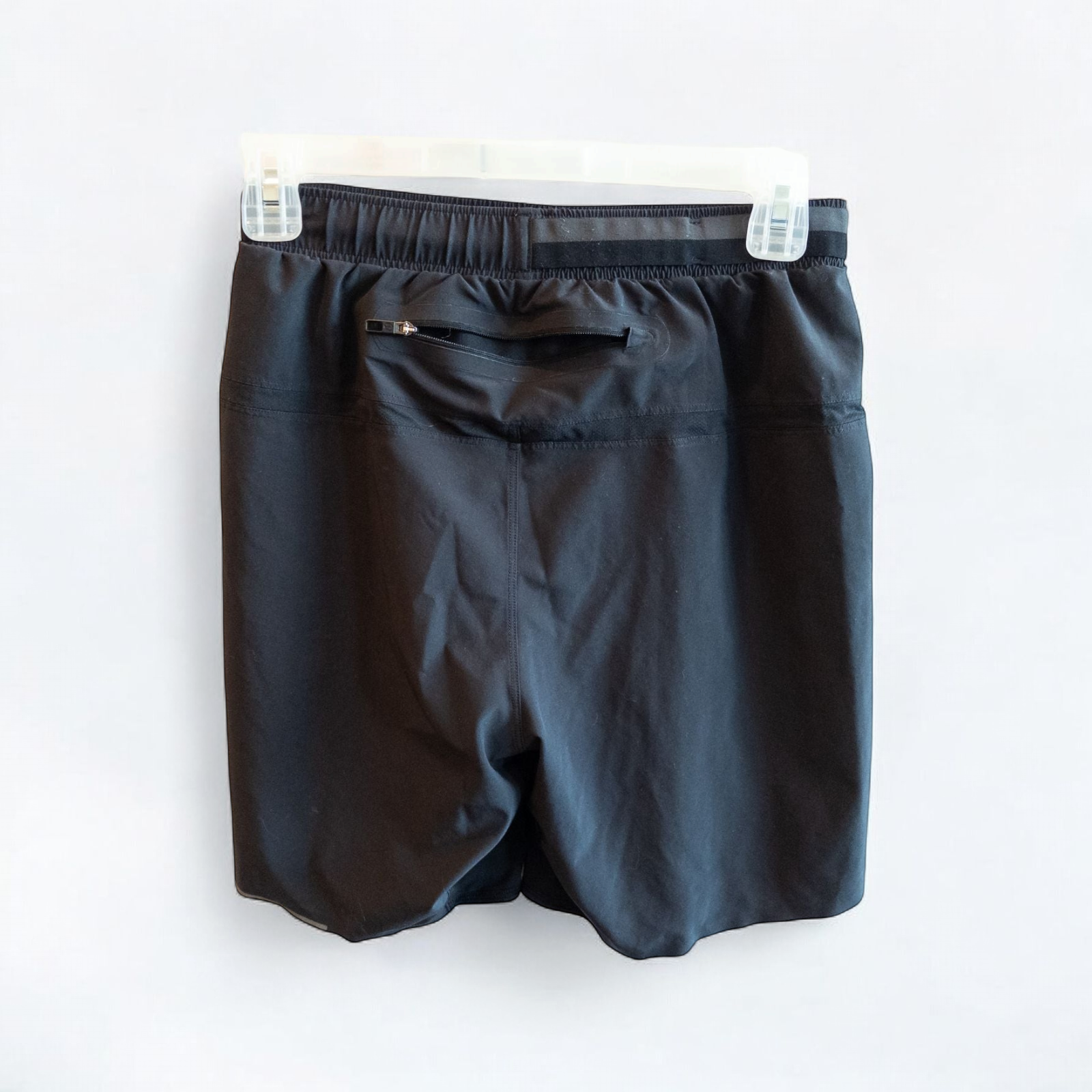 Black lululemon men's lightweight athletic shorts with elastic waistband and drawstring tie hanging on clips image 5