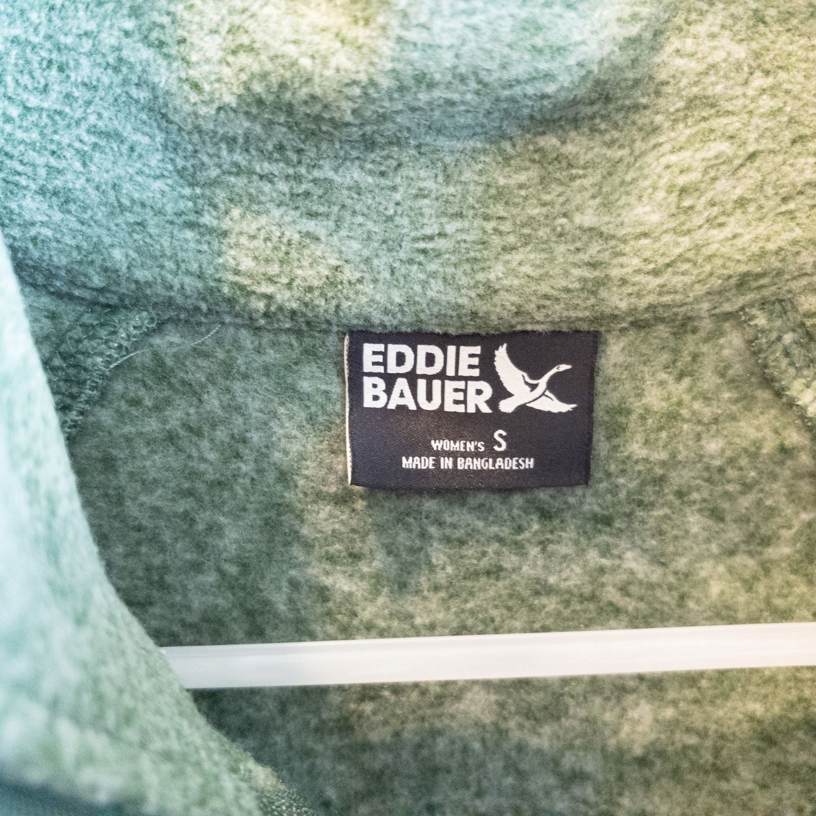 Eddie Bauer green quarter zip sweatshirt hanging on a plastic hanger showing front, back, collar, and inside label image 6