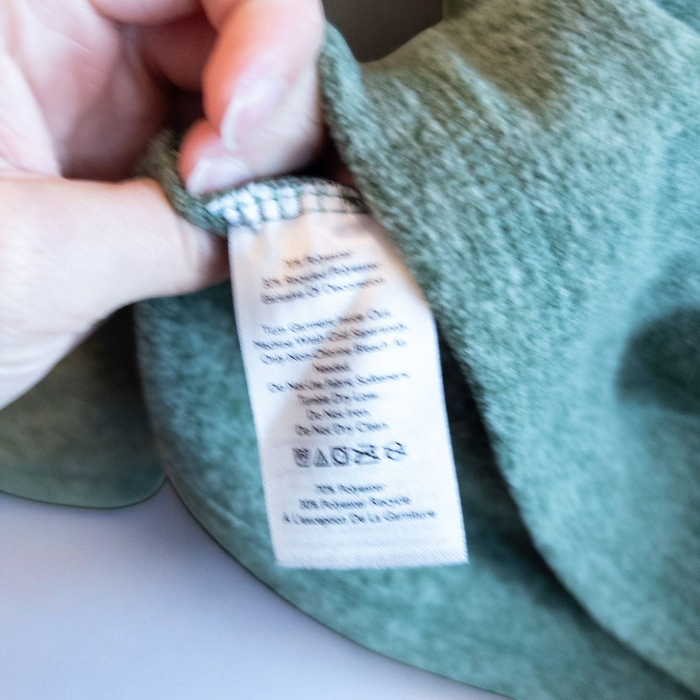 Eddie Bauer green quarter zip sweatshirt hanging on a plastic hanger showing front, back, collar, and inside label image 7