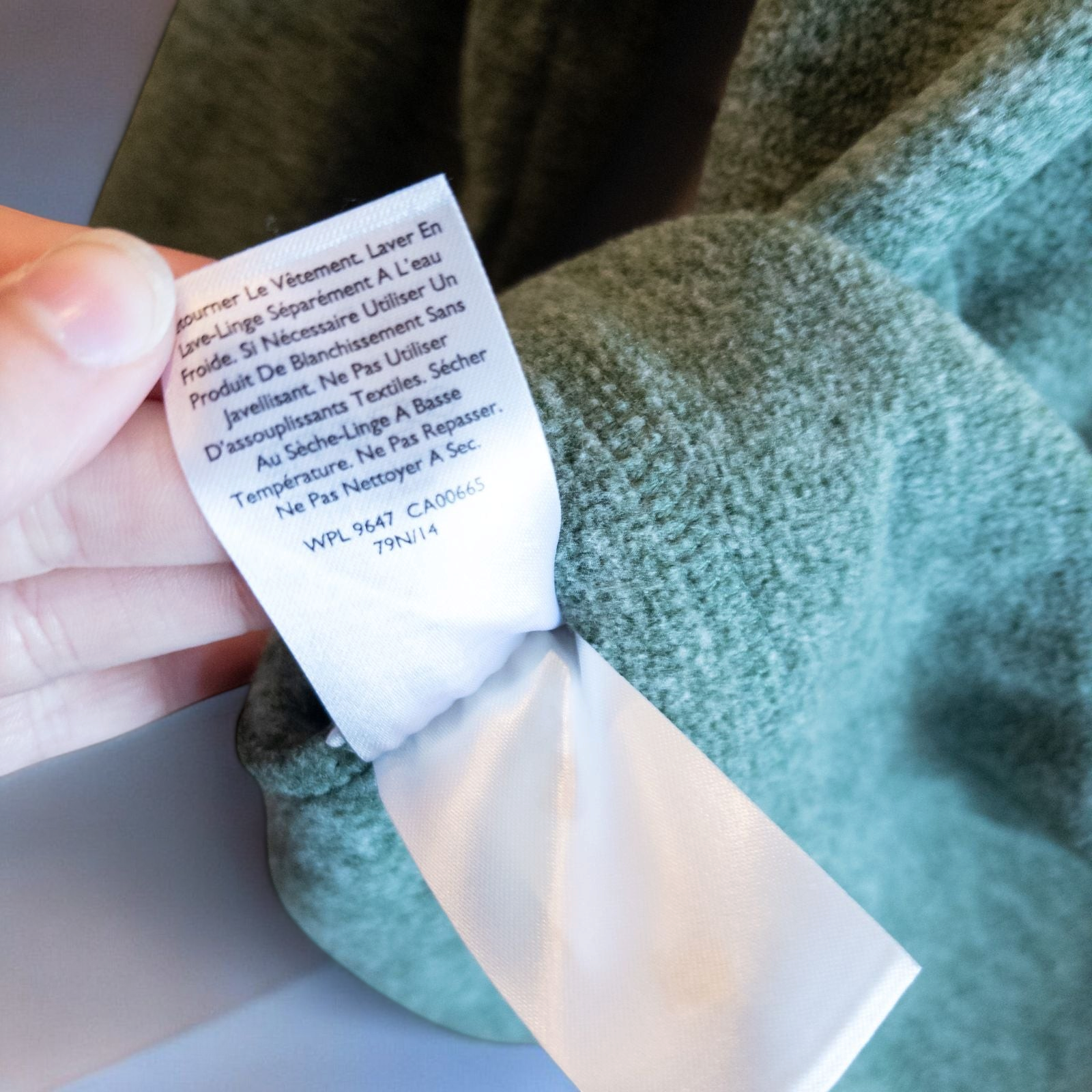 Eddie Bauer green quarter zip sweatshirt hanging on a plastic hanger showing front, back, collar, and inside label image 8