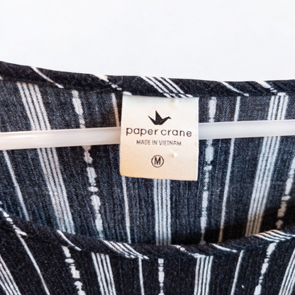 Paper Crane black and white striped peplum blouse with round neck and flutter sleeves hanging on white door image 5