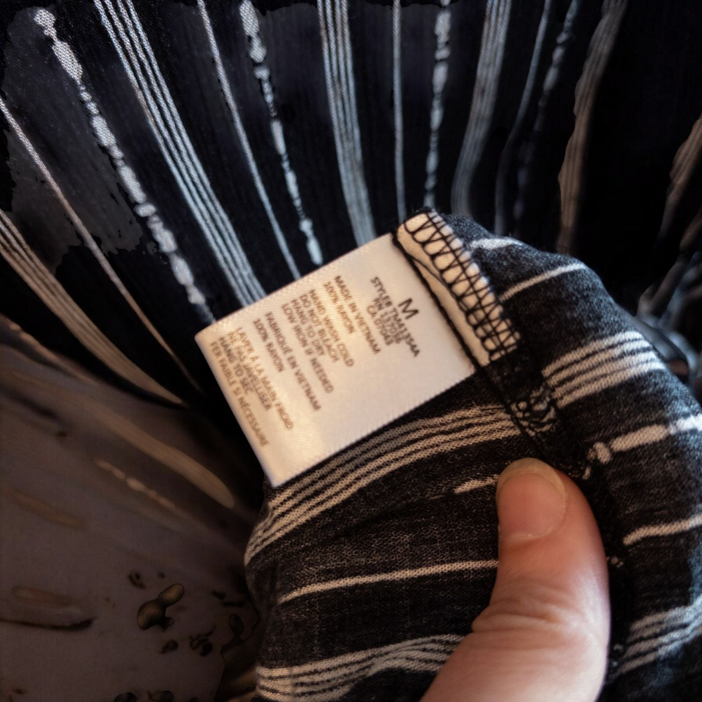 Paper Crane black and white striped peplum blouse with round neck and flutter sleeves hanging on white door image 6