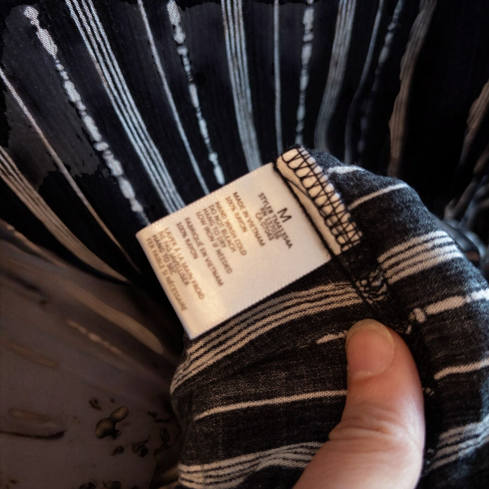 Paper Crane black and white striped peplum blouse with round neck and flutter sleeves hanging on white door image 6