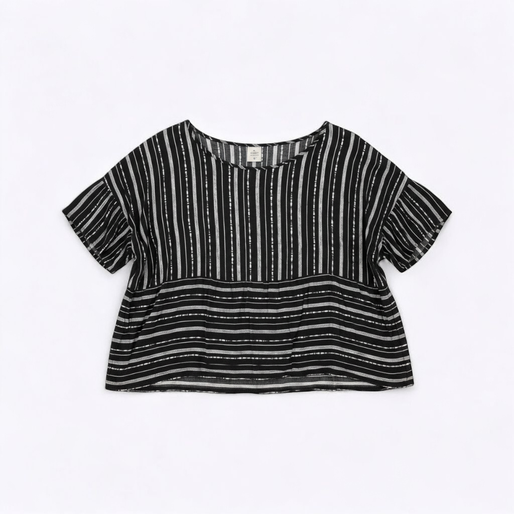 Paper Crane black and white striped peplum blouse with round neck and flutter sleeves hanging on white door front on white muslin photography backdrop