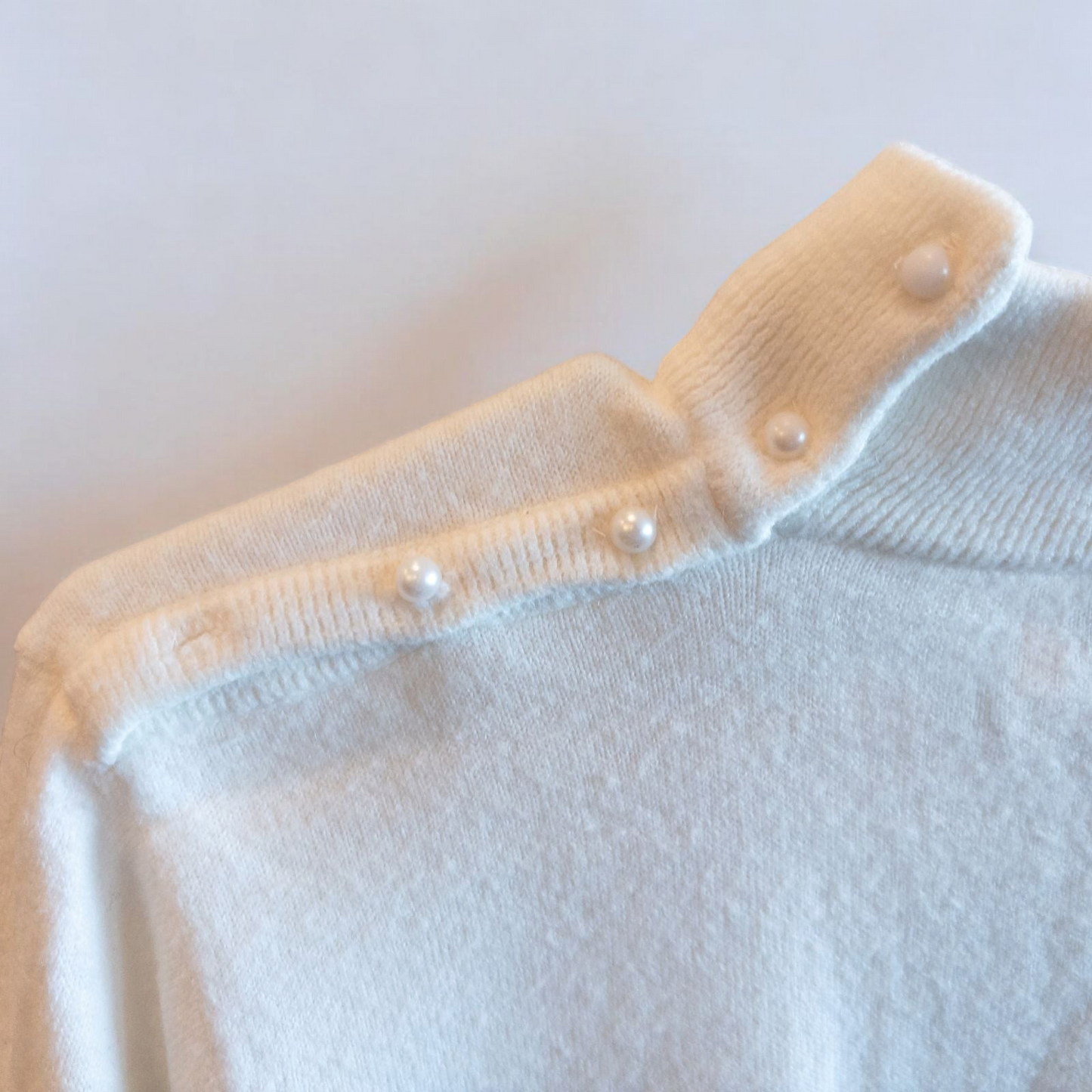 Designers Originals white women’s medium turtleneck sweater with pearl buttons on shoulder hanging on hanger image 4
