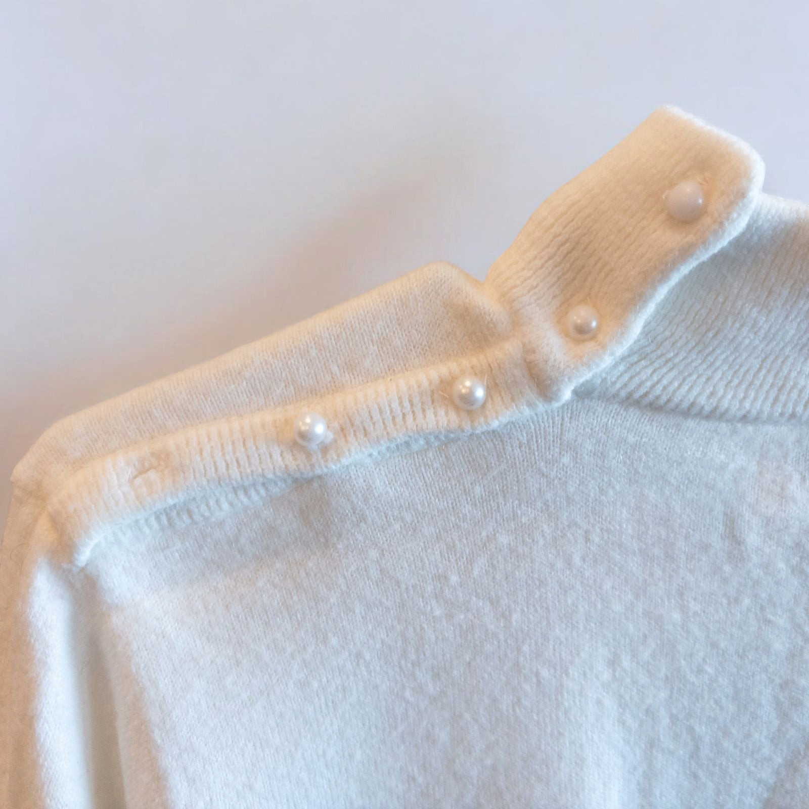 Designers Originals white women’s medium turtleneck sweater with pearl buttons on shoulder hanging on hanger image 4