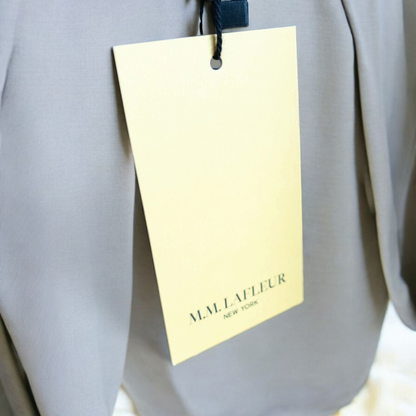 Gray MM LaFleur tech pants hanging on a hanger front and back views with close up of waistband, zipper, and label image 10